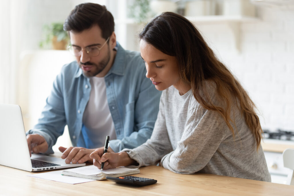 Focused,Millennial,Husband,And,Wife,Sit,At,Desk,At,Home